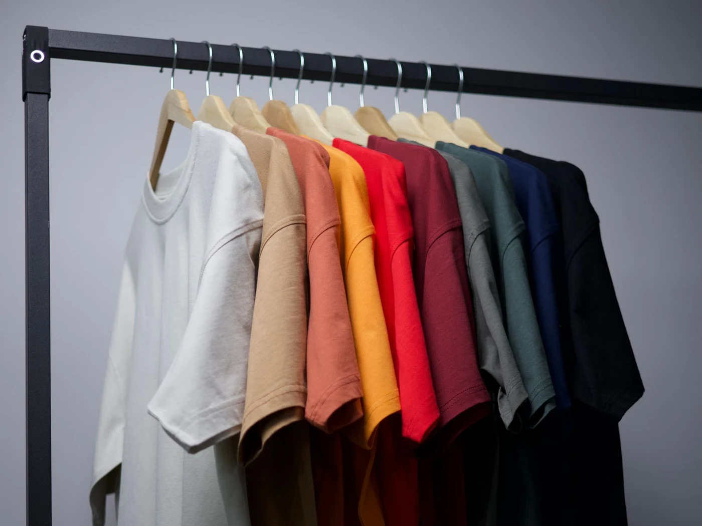 Rek met effen T-shirts in verschillende kleuren, klaar voor personalisatie
